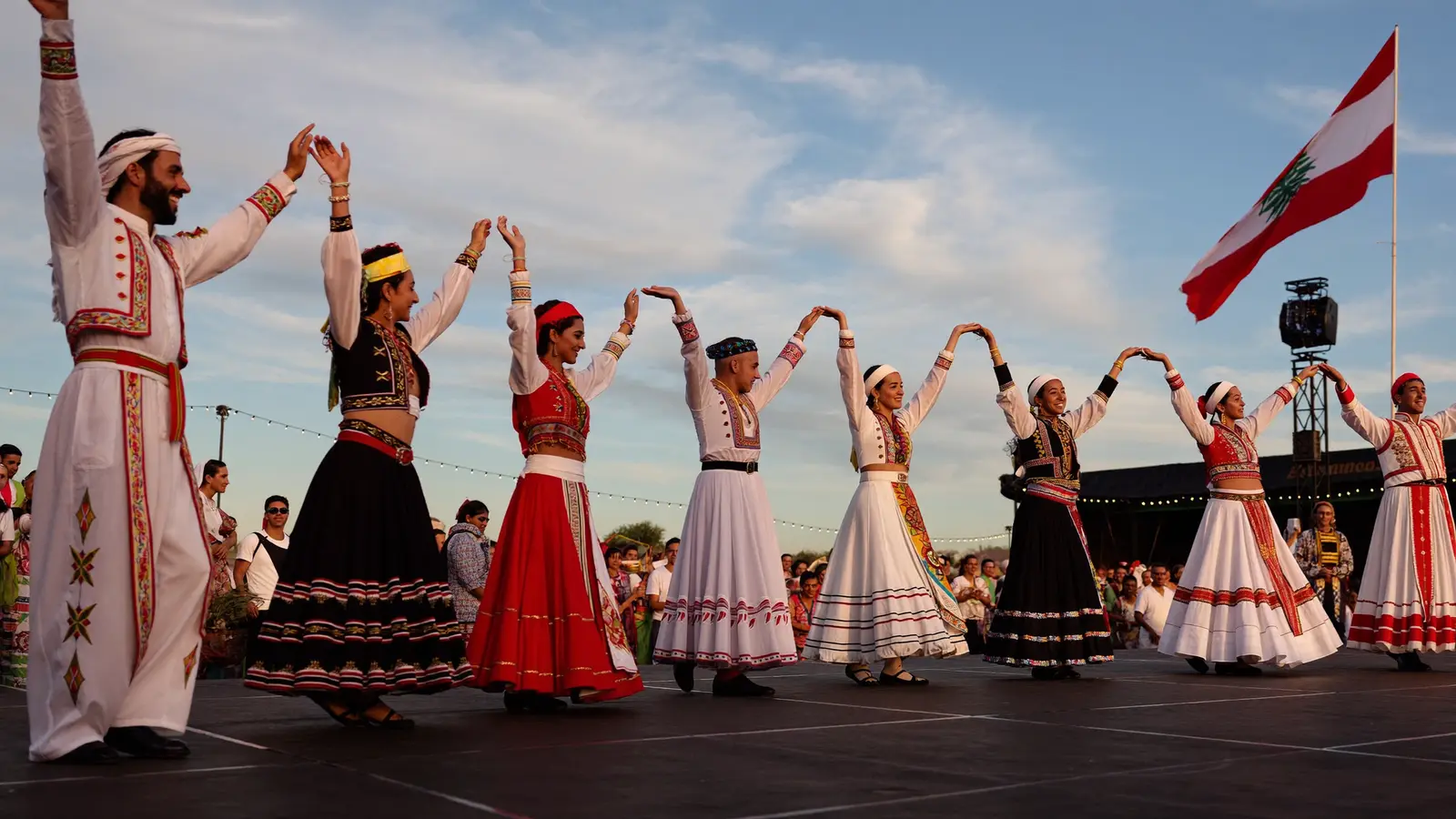 Dabke folk dancers in traditional dress performing in a line at the festival